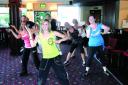 HARD WORK: Zumba instructor Sarah Clarke, seen in the green top, leads the Zumbathon organised by her firend and hospital volunteer, Emily Gee, pictured in the blue Pineapple top.