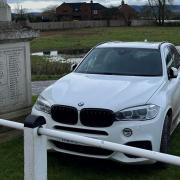 White BMW parked on a war memorial in Severn Stoke.