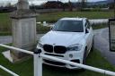 White BMW parked on a war memorial in Severn Stoke.