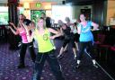 HARD WORK: Zumba instructor Sarah Clarke, seen in the green top, leads the Zumbathon organised by her firend and hospital volunteer, Emily Gee, pictured in the blue Pineapple top.