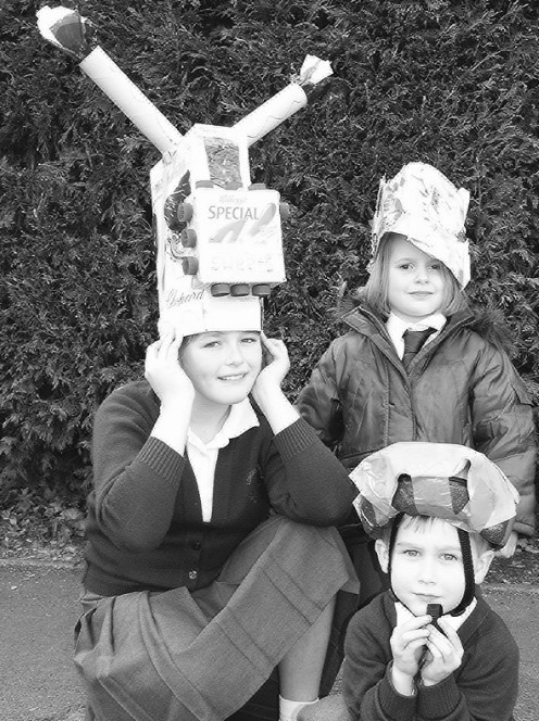 Laura Scott, Grace Cox and Jamie Schermer try out their hats made from recycled materials as part of Eco Day at Longdon Primary School in October 2003