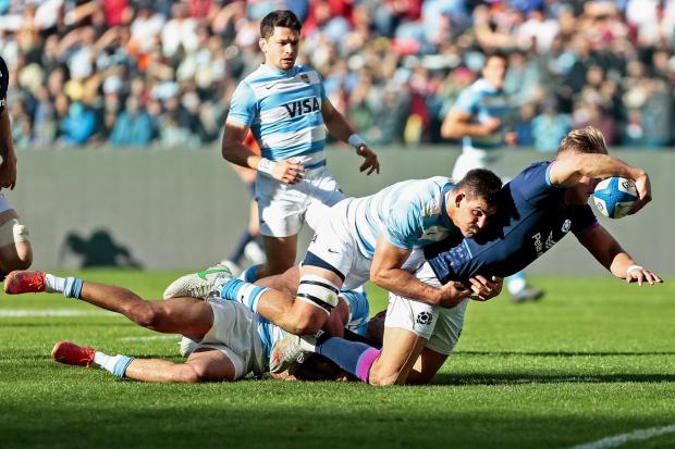 Scotland's Duhan van der Merwe (R) dives over the line to score a try during the series-deciding international rugby union third test match against Argentina at the Madre de Ciudades Stadium in Santiago del Estero, Argentina, on July 16, 2022. (Photo