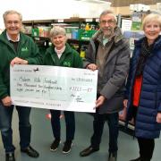 Foodbank volunteers receive the donation from choir members