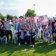 Malvern Town players, coaches and staff celebrate after securing their promotion