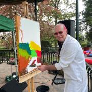 COLOUR: Artist Phil Ironside paints on the bandstand in Priory Park for Malvern Water and Well Dressing Festival